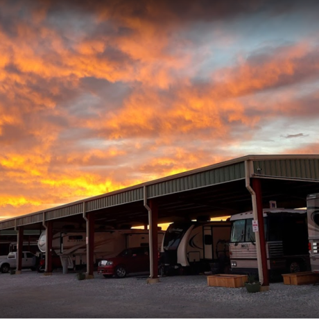 A row of RVs parked at full hookup sites, surrounded by the park’s natural beauty, illustrating the inviting atmosphere for extended stays at Texas Lakes Ranch RV Park in Aubrey, TX